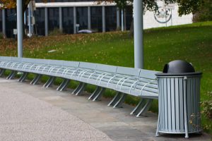 row of benches with a trash can at the end