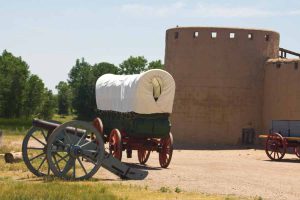 wagon and cannon beside the fort