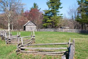 a wooden fence leading to a log cabin