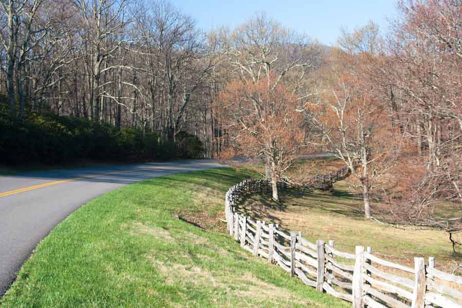 A wooden fence follows a curve in the parkway.