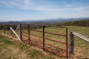 a gate to a field with mountains in background