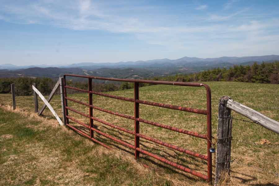 a gate to a field with mountains in background