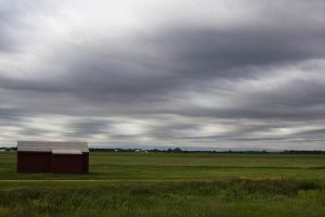 a small building below a moody sky