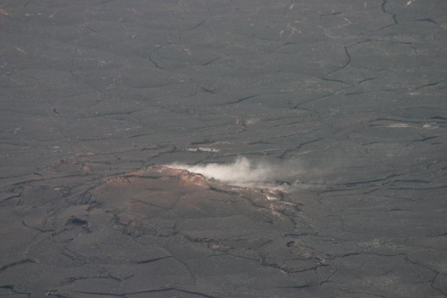 A fissure in the hardened lava rock is smoking.