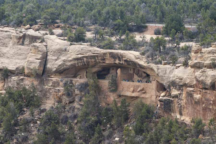 a tour group at the dwellings in the side of a cliff