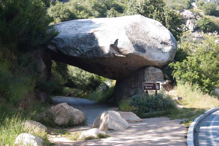 an old road goes under a boulder
