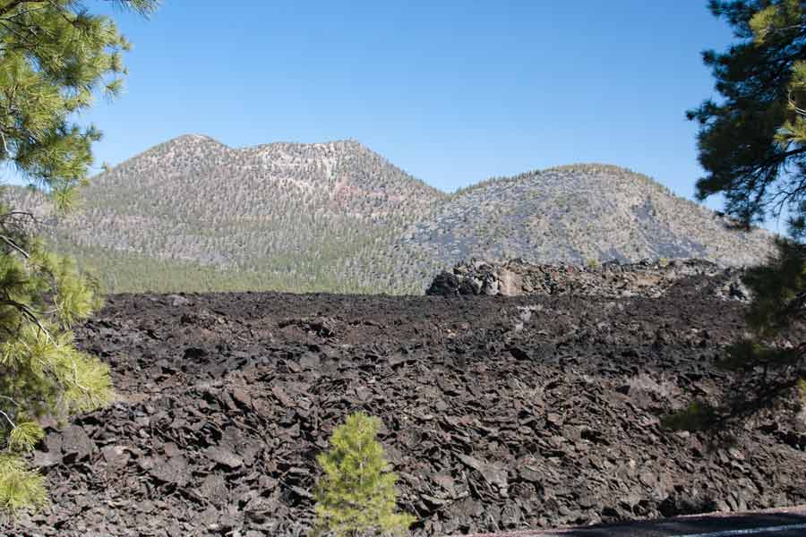 black lava field with mountains in background