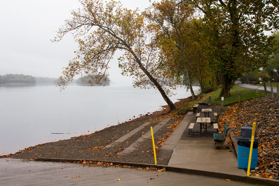 two picnic tables and two benches beside the river