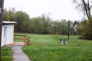 the edge of a grassy field with a small hill around it