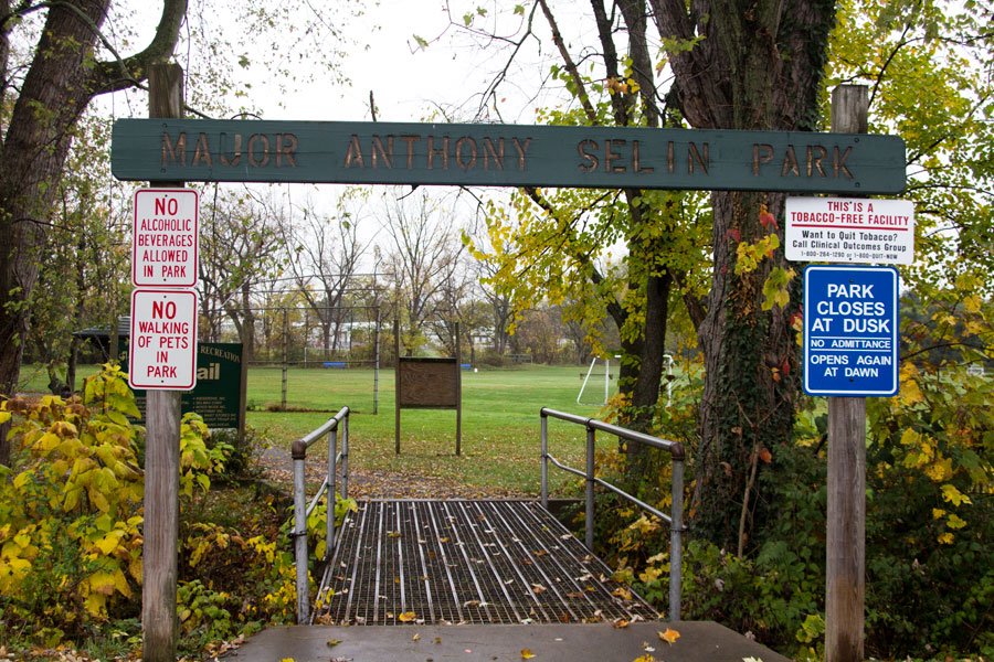 Major Anthony Selin Park sign over metal grate walking bridge