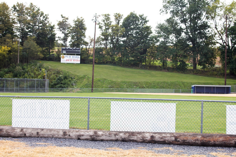 scoreboard on a hill behind ball field