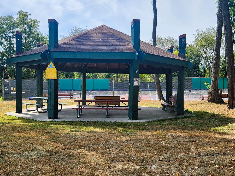 pavilion with two picnic tables and two benches.