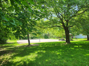 basketball court and pavilion behind trees.